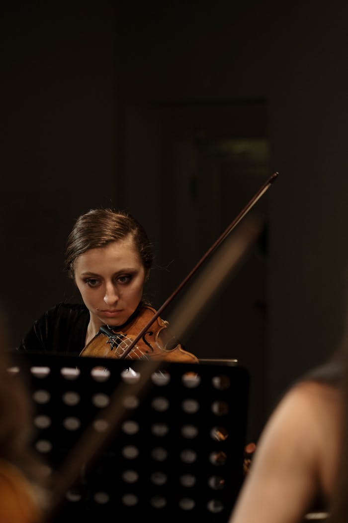 our-story-01 Focused young violinist plays passionately indoors, creating serene atmosphere.